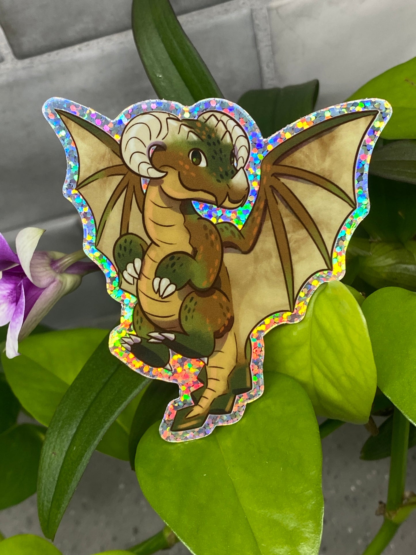 a sticker of a dragon sitting on top of a plant