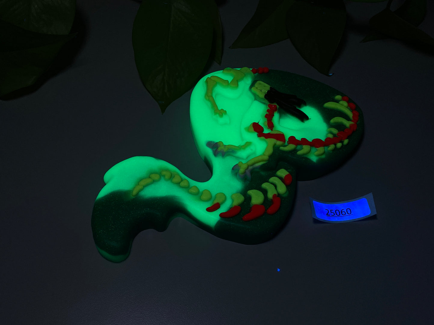 a green and red snake cake sitting on top of a table