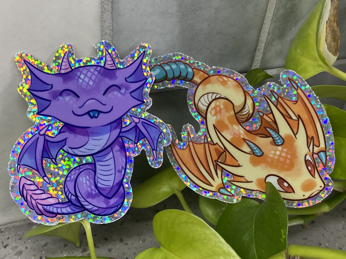 a couple of stickers sitting on top of a plant