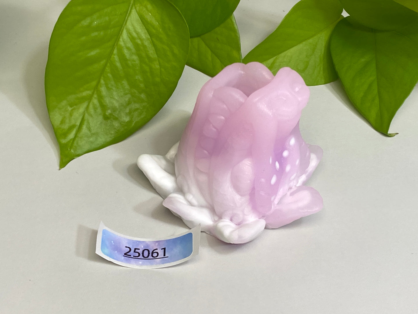 a pink flower sitting on top of a white table