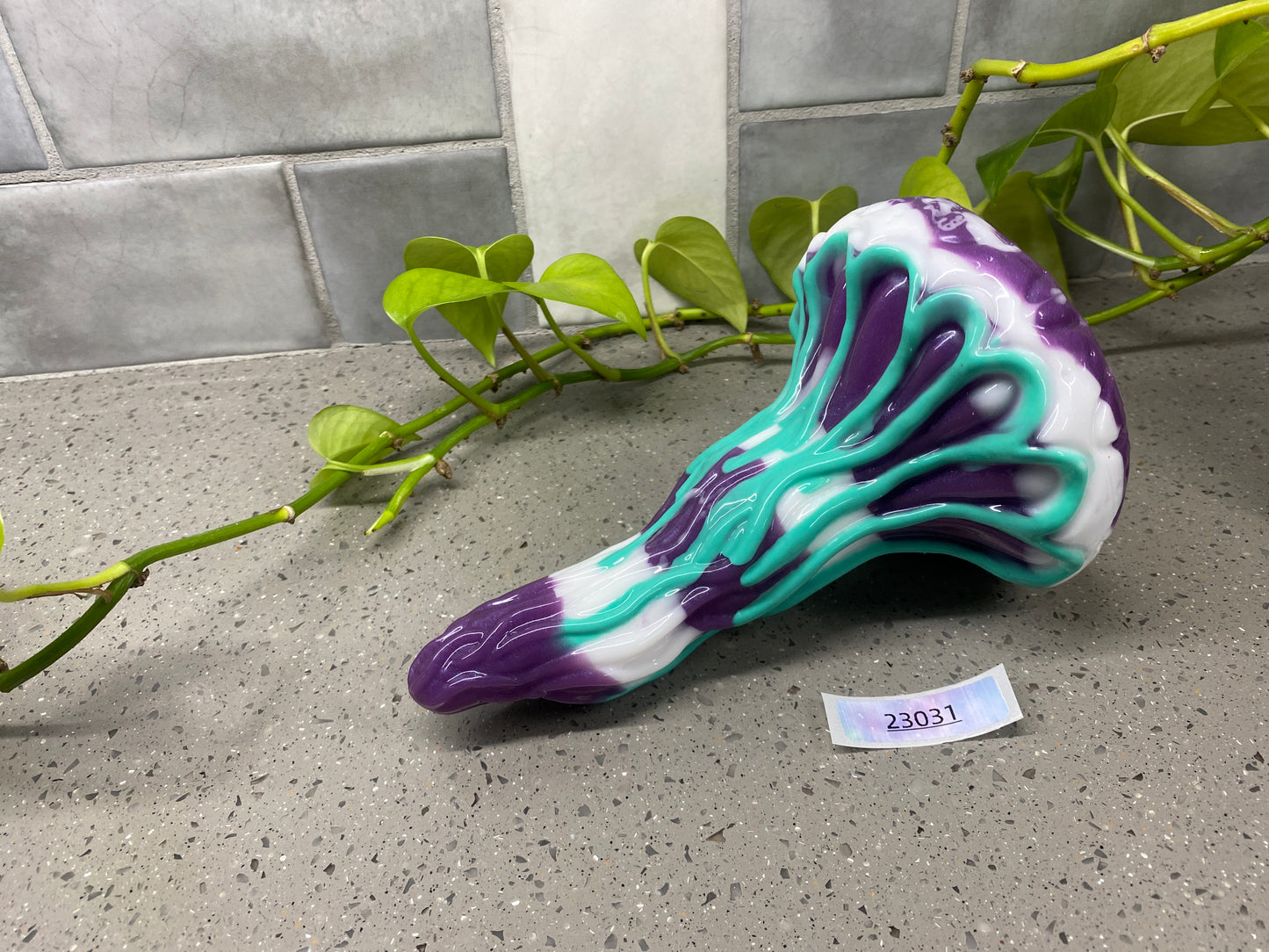 a purple and blue shoe sitting next to a plant