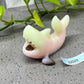 a ceramic figurine of a fish with its mouth open next to a plant