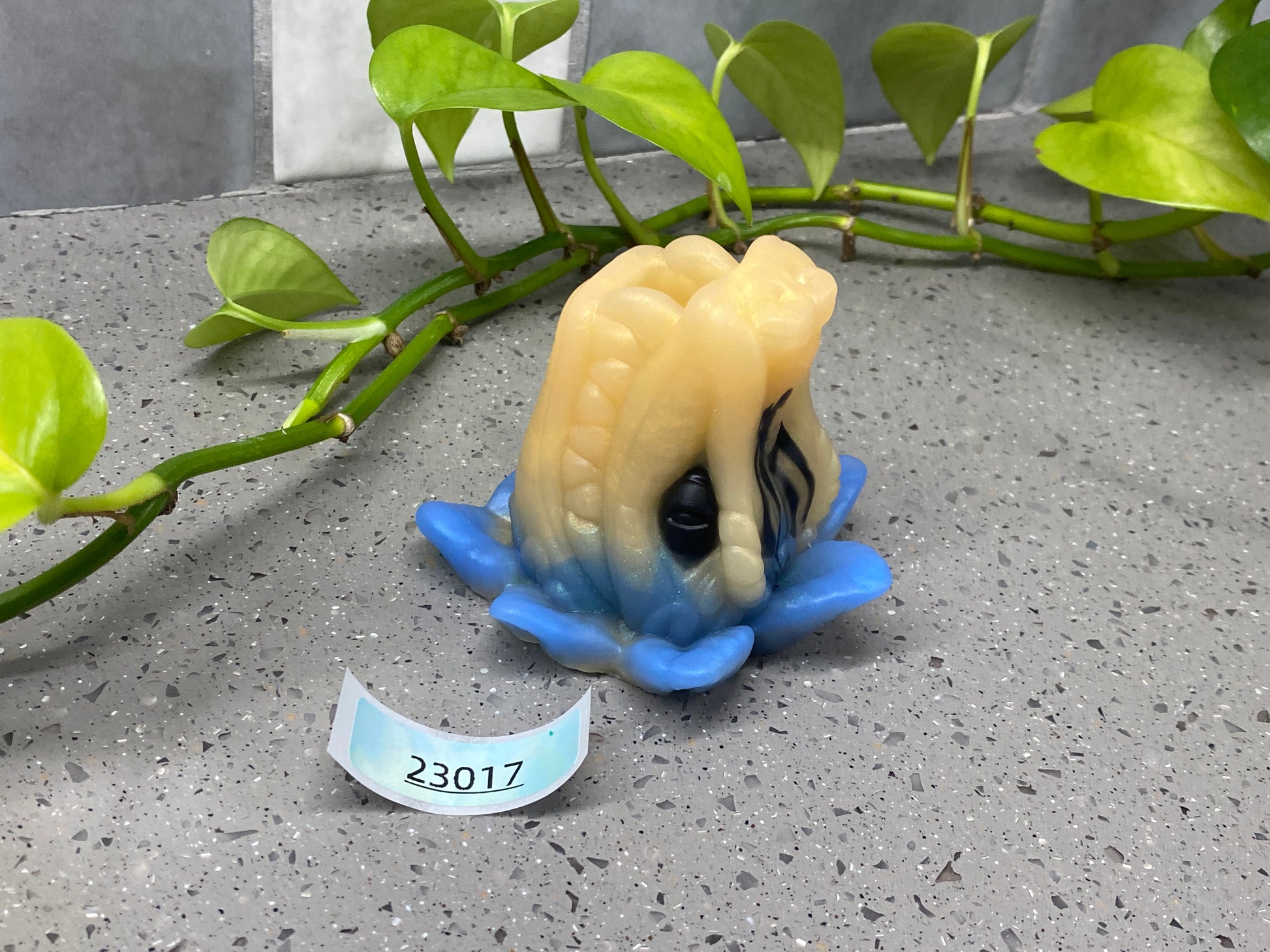 a small figurine sitting on top of a blue flower