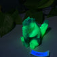 a glowing green teddy bear sitting on top of a table