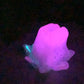 a purple flower that is glowing in the dark