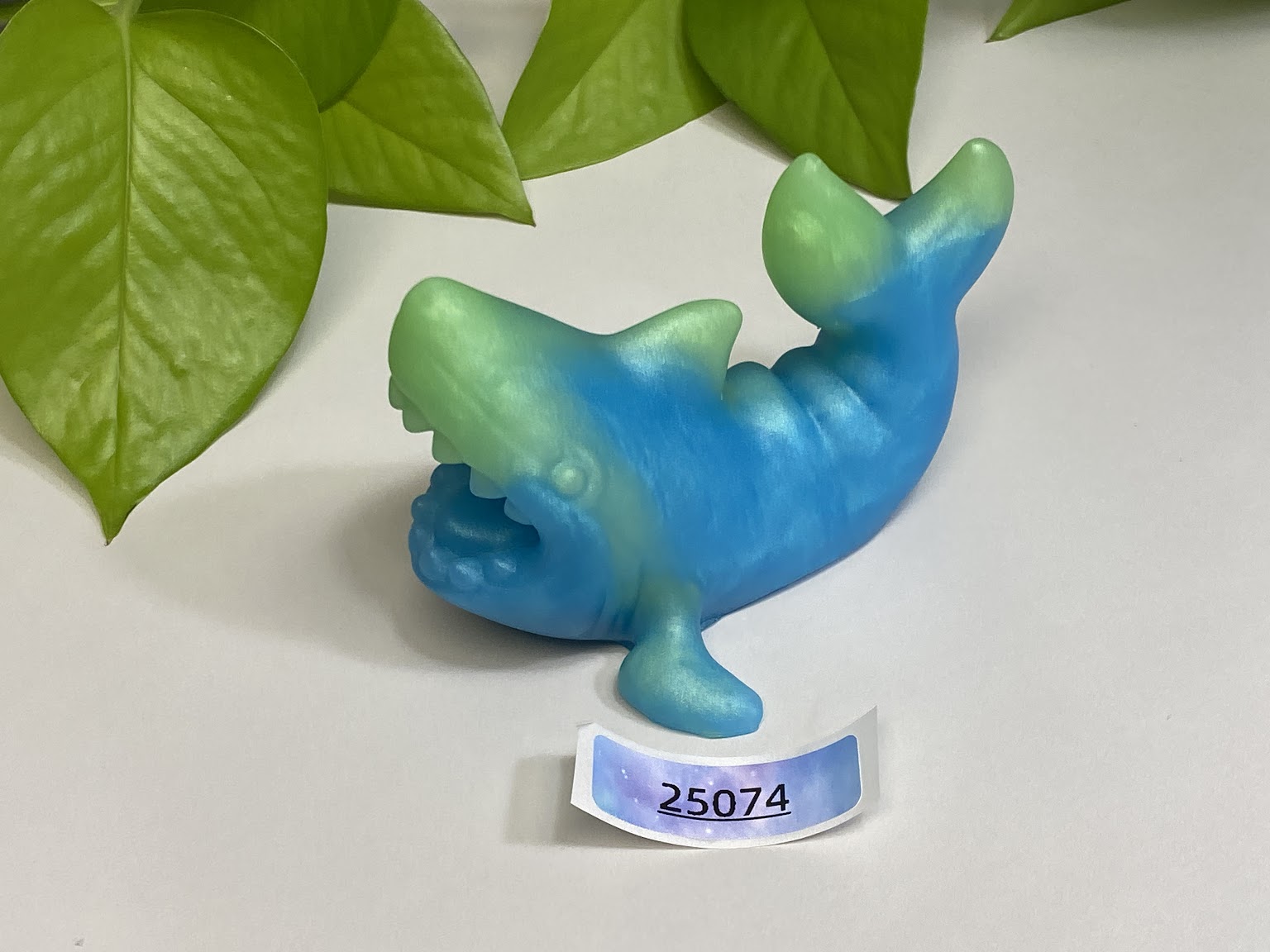 a blue and green plastic toy with a name tag