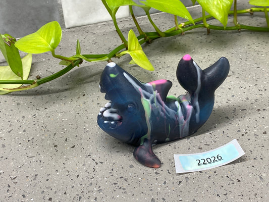 a ceramic figurine of a fish laying on the ground