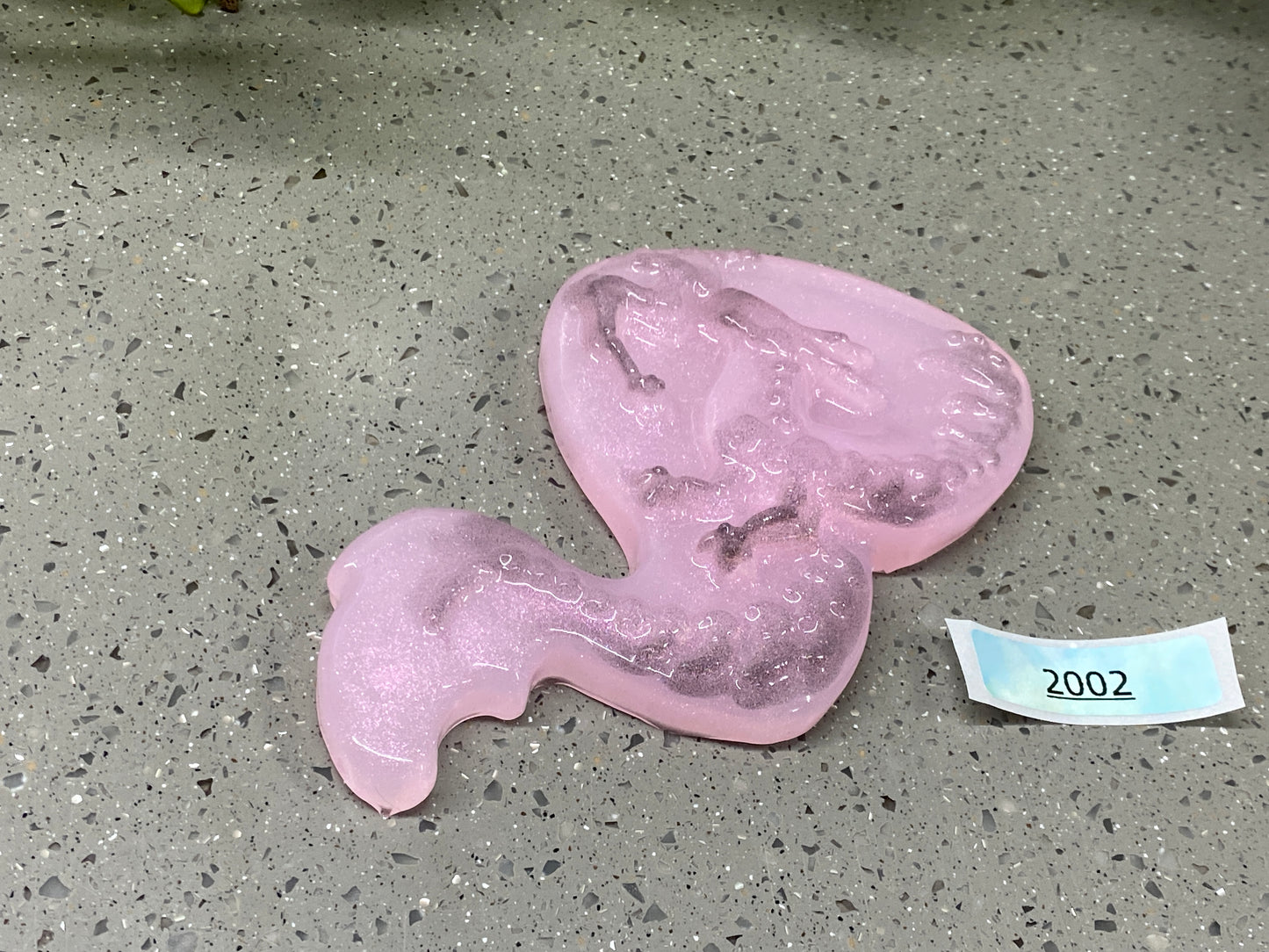 a pink object on the ground next to a piece of paper