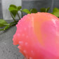 a close up of a soap ball with a plant in the background