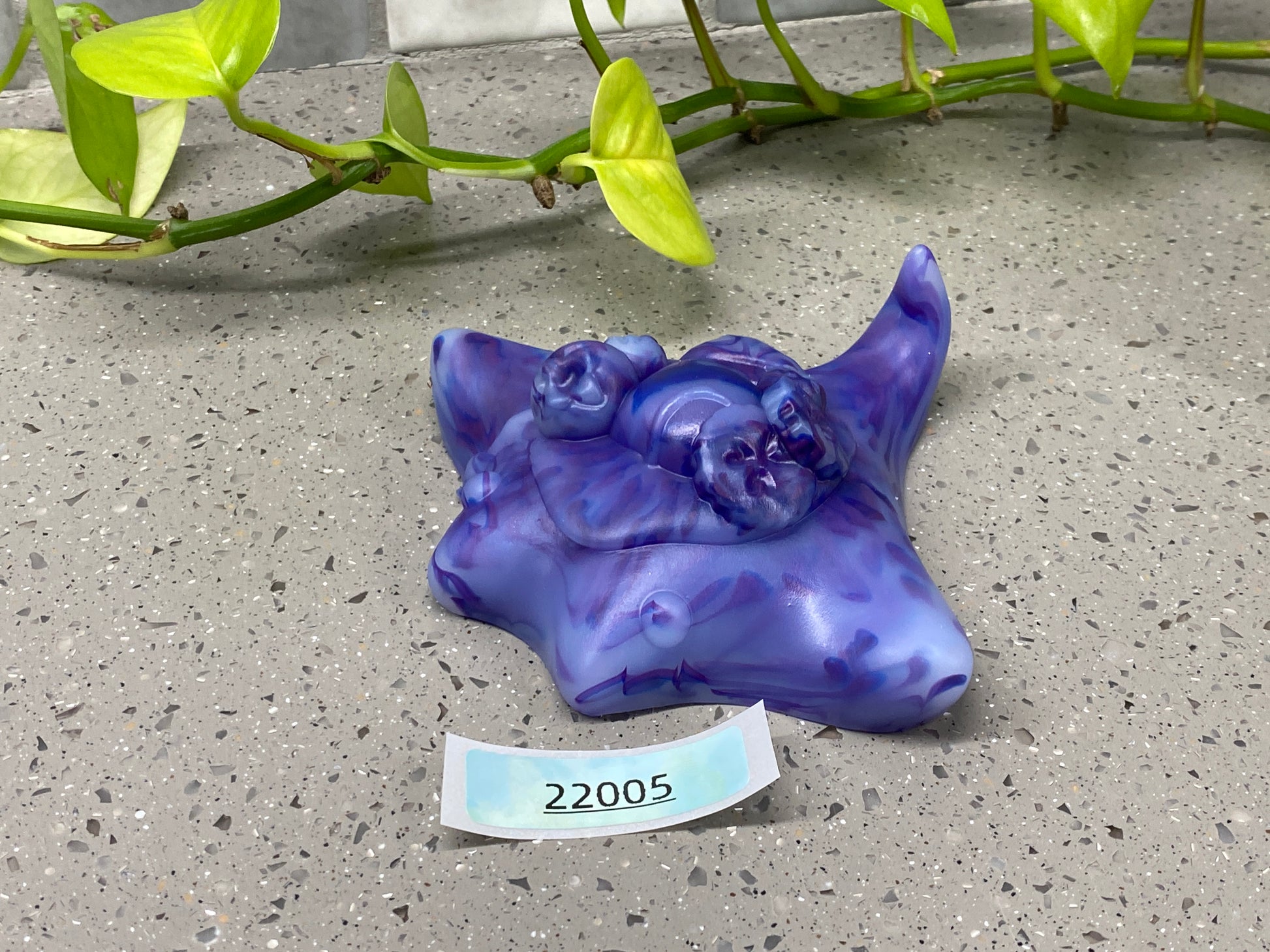 a purple sculpture of a cow with a name tag