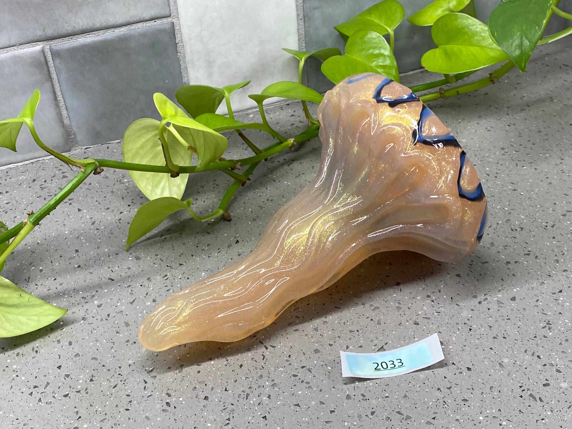 a piece of glass sitting on top of a counter next to a plant