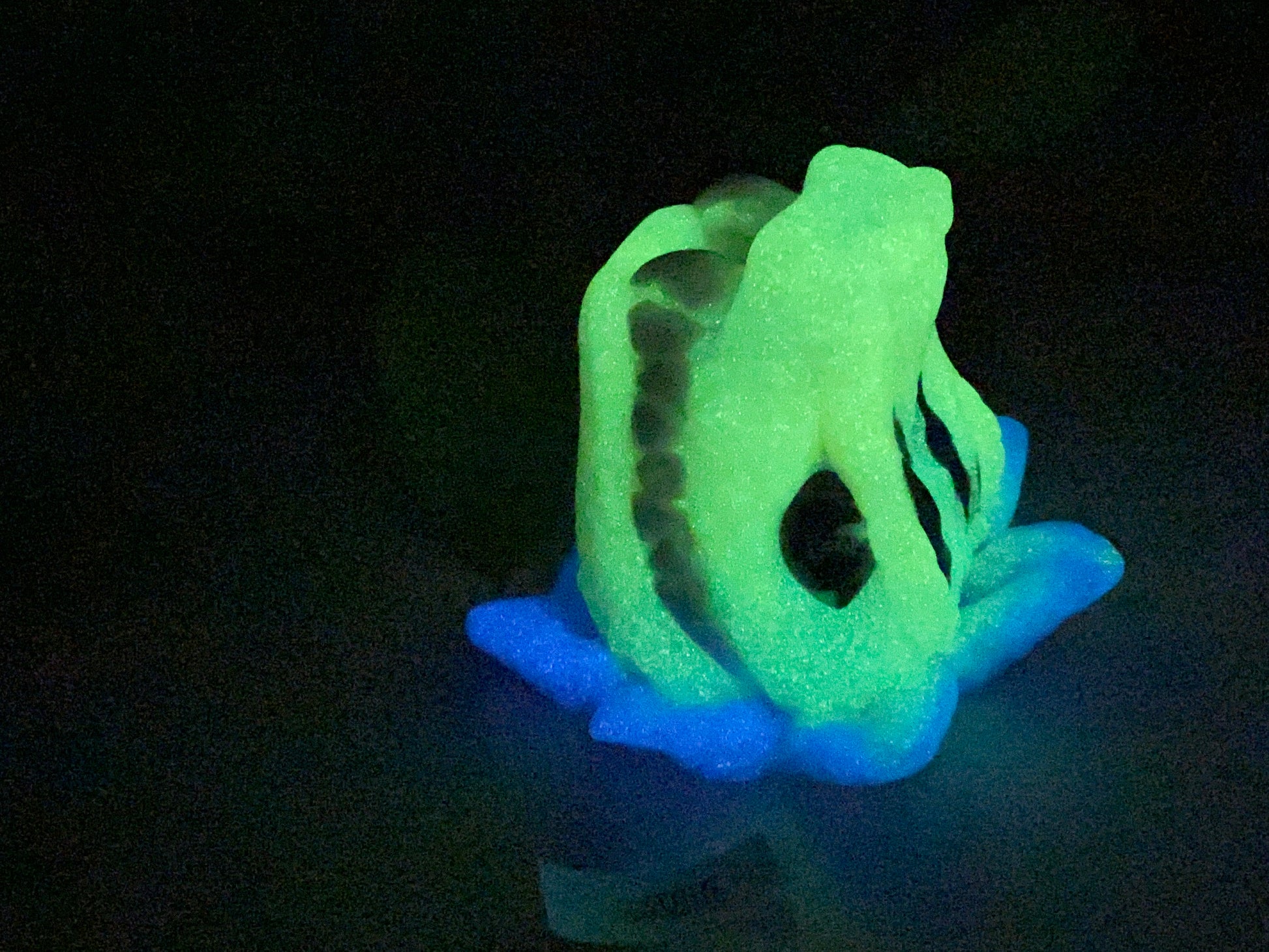 a glowing green and blue object sitting on top of a table