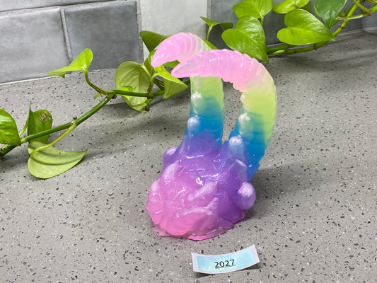 a purple and blue vase sitting on top of a counter