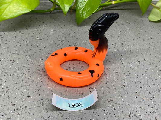 an orange and black ring sitting on top of a table