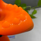 a close up of an orange object with a plant in the background