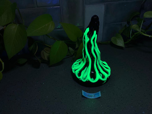 a black vase with a green glow on it