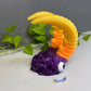 a purple and yellow toy with a dragon on top of it