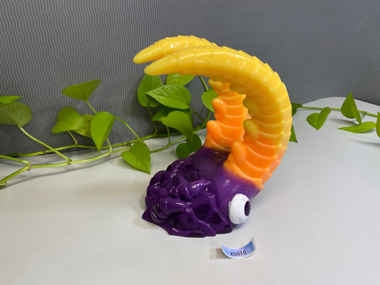 a purple and yellow toy with a dragon on top of it