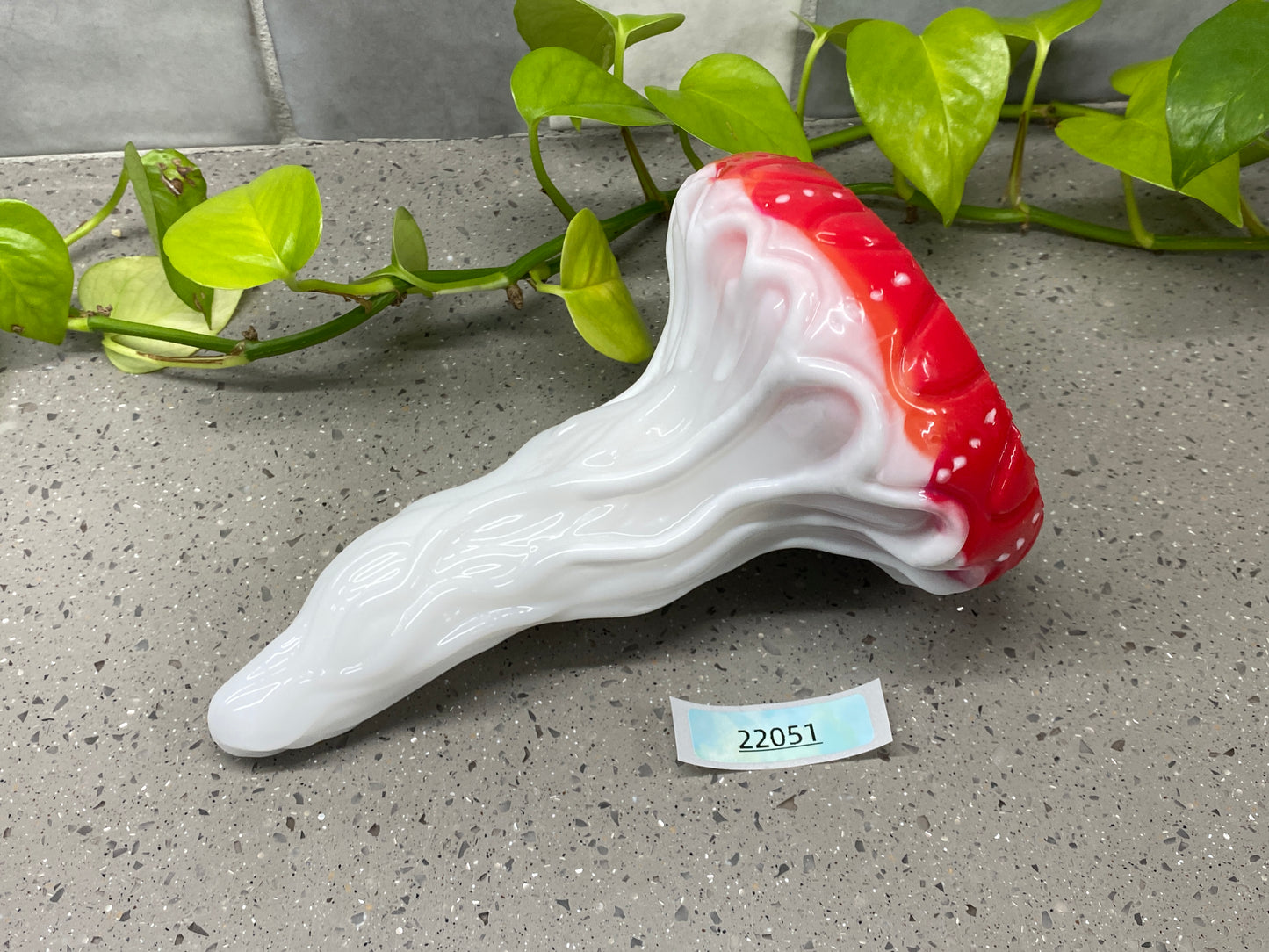 a red and white vase sitting on top of a table