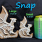 a cookie shaped like a dragon next to a can of soda