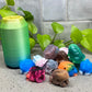 a group of small plastic animals sitting next to a can