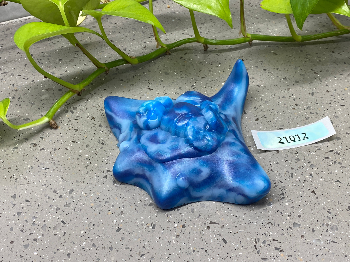 a blue ceramic object sitting next to a plant