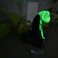 a black and white cat with a green glow on it's head