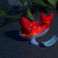 a red and white toy fish sitting on top of a table