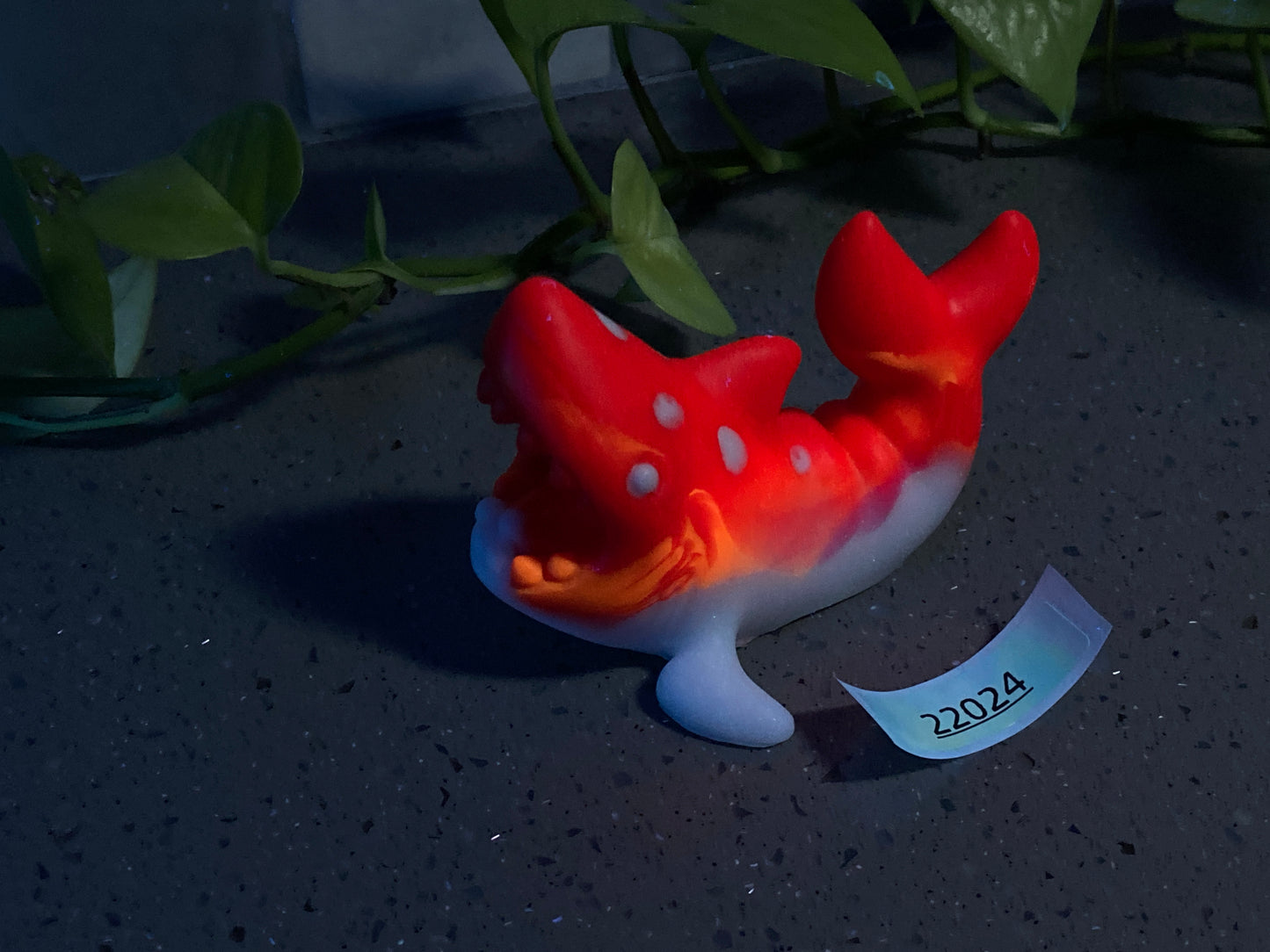 a red and white toy fish sitting on top of a table