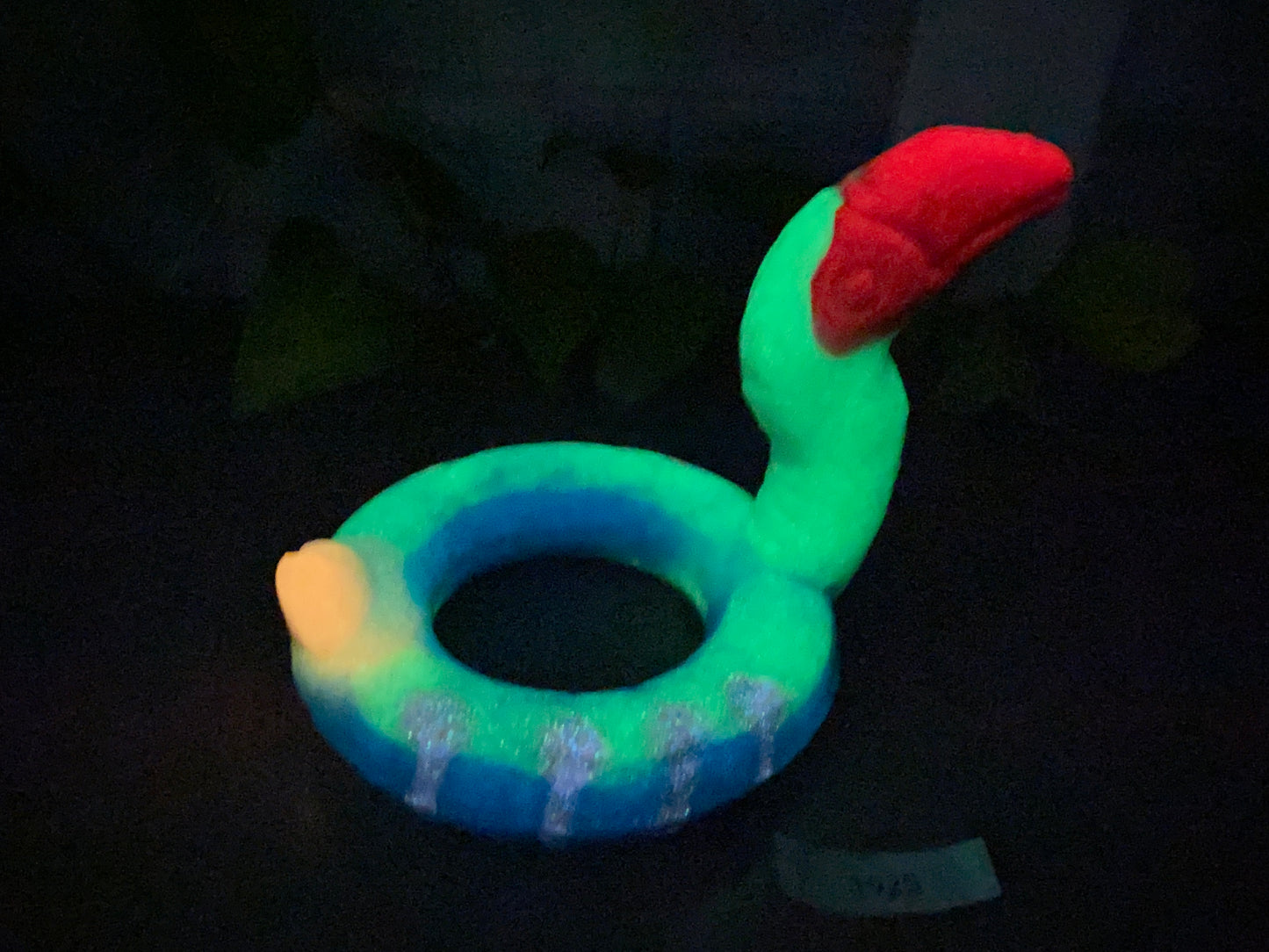 a green and blue ring with a red hat on it