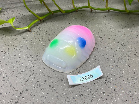 a plastic object with a tag on it sitting next to a plant