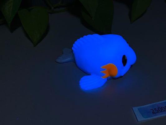 a blue toy with an orange beak laying on a table