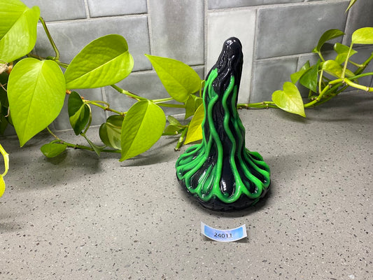 a green and black vase sitting on top of a counter