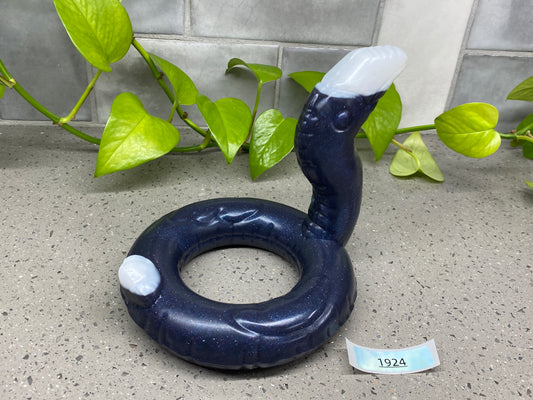a blue object sitting on top of a counter next to a plant