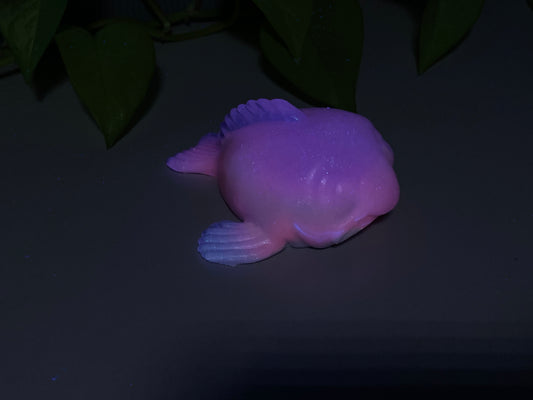 a purple plastic fish sitting on top of a table