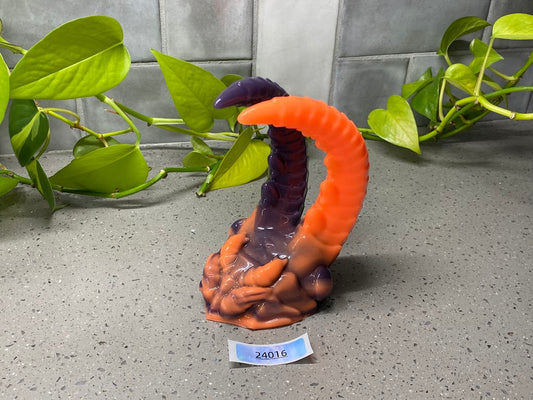 a fake snake is on a table next to a plant