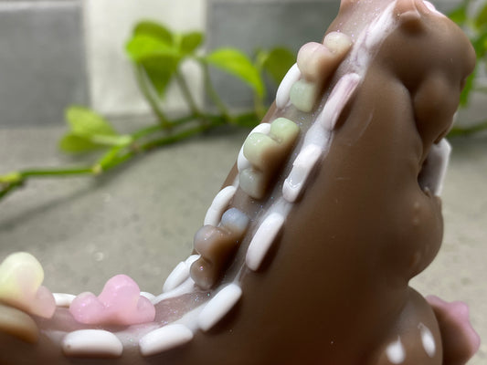 a close up of a chocolate bear with gummy bears on it's teeth