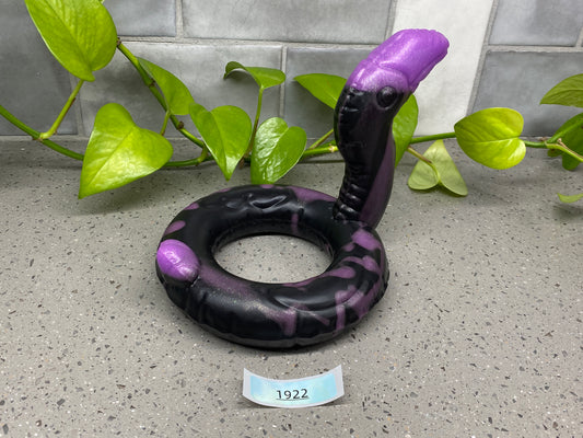 an inflatable snake is on the ground next to a plant