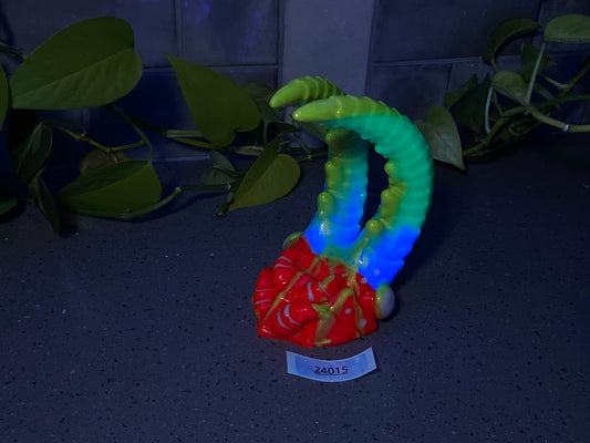 a colorful vase sitting on top of a table next to a plant