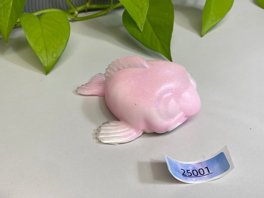 a pink toy fish sitting on top of a table