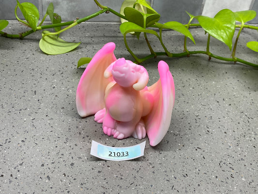 a figurine of a pink dragon with a name tag