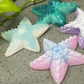 a group of starfish shaped soaps sitting next to a plant