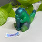 a green toy sitting on top of a white table