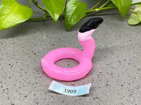 an inflatable pink ring sitting on top of a table next to a plant