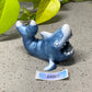 a blue ceramic dolphin figurine with its mouth open