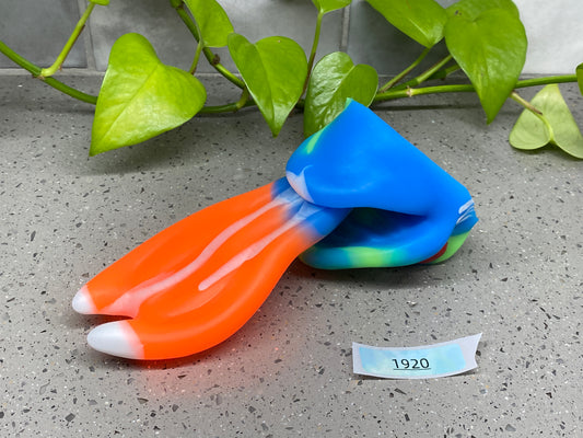 a pair of toothbrushes sitting on top of a table next to a plant
