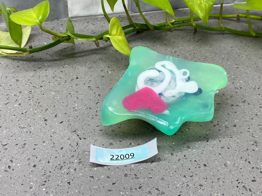 a green and pink soap sitting on top of a counter