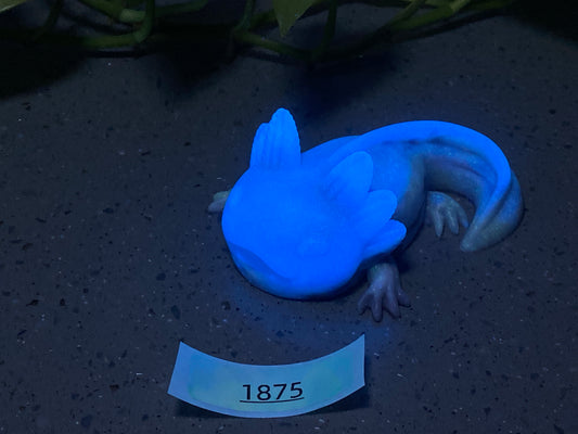 a blue gecko laying on the ground next to a sign