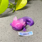 a purple and purple toy laying on top of a cement ground