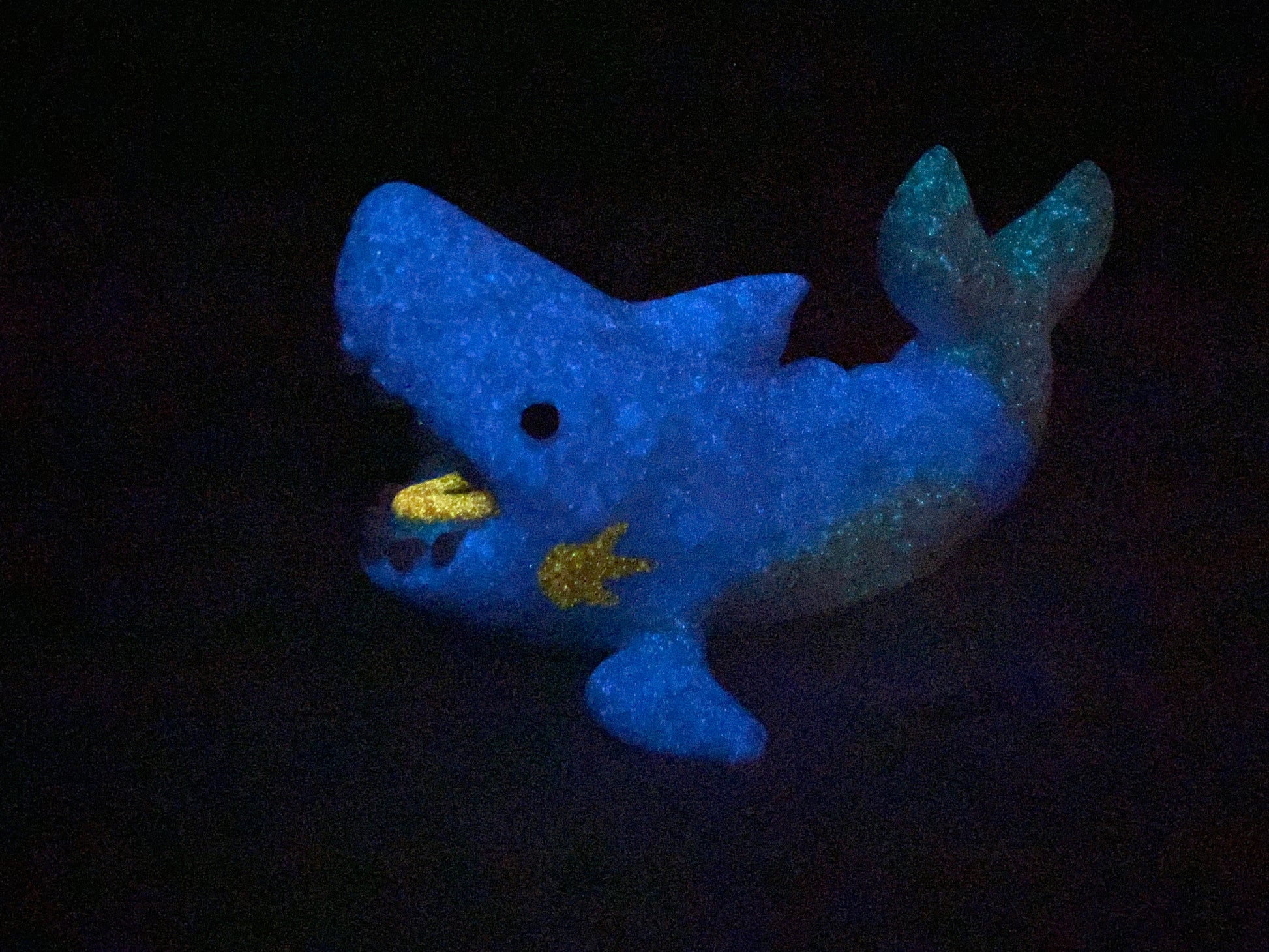 a blue stuffed animal that is glowing in the dark